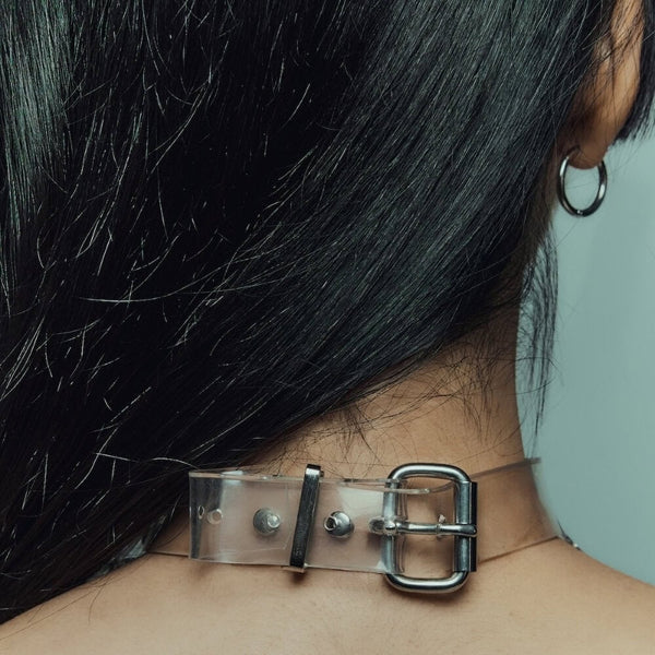 Modèle portant le Cosmic Choker Perlensau en matière transparente avec chaînes métalliques et pampilles suspendues, proposé par Brigade Mondaine Paris.