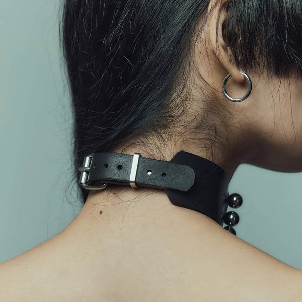 Trinity Choker Perlensau en cuir noir avec barres métalliques et sphères argentées, proposé par Brigade Mondaine Paris.