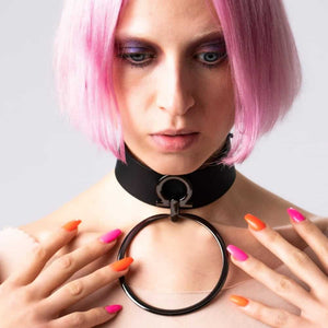 Modèle portant le choker Divine Perlensau en cuir noir avec large anneau métallique suspendu, proposé par Brigade Mondaine Paris.