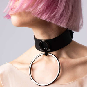 Modèle portant le choker Divine Perlensau en cuir noir avec large anneau métallique suspendu, proposé par Brigade Mondaine Paris.