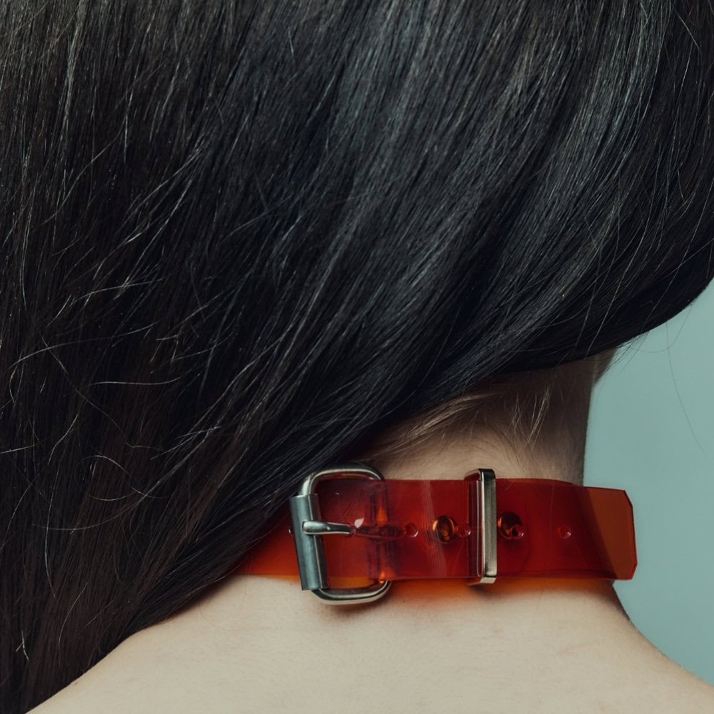 Modèle portant le Industrial Choker rouge Perlensau en cuir avec tiges métalliques et sphères argentées, proposé par Brigade Mondaine Paris.
