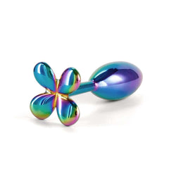 Plug anal en acier inoxydable finition irisée, motif fleur à la base, présenté sur fond clair, sélection Brigade Mondaine Paris.