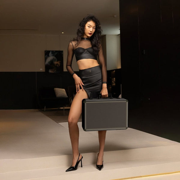 Mallette UPKO en aluminium portée à la main, tenue noire minimaliste, sélection Brigade Mondaine Paris