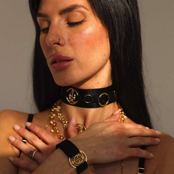 A woman in a black lingerie with gold chains.