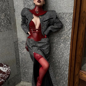 Mannequin portant le collier Posture Hold en cuir rouge RE:STRICT chez Brigade Mondaine Paris, pièce rigide couvrant le cou, anneau métallique central, porté avec un top en mesh noir en studio.