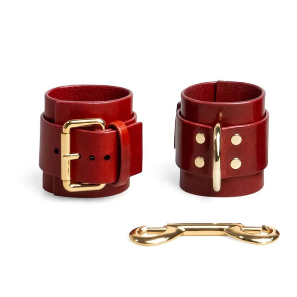 Menottes en cuir rouge ajustables avec D-ring et lien métallique doré création bondage minimaliste et artisanale signée RE:STRICT