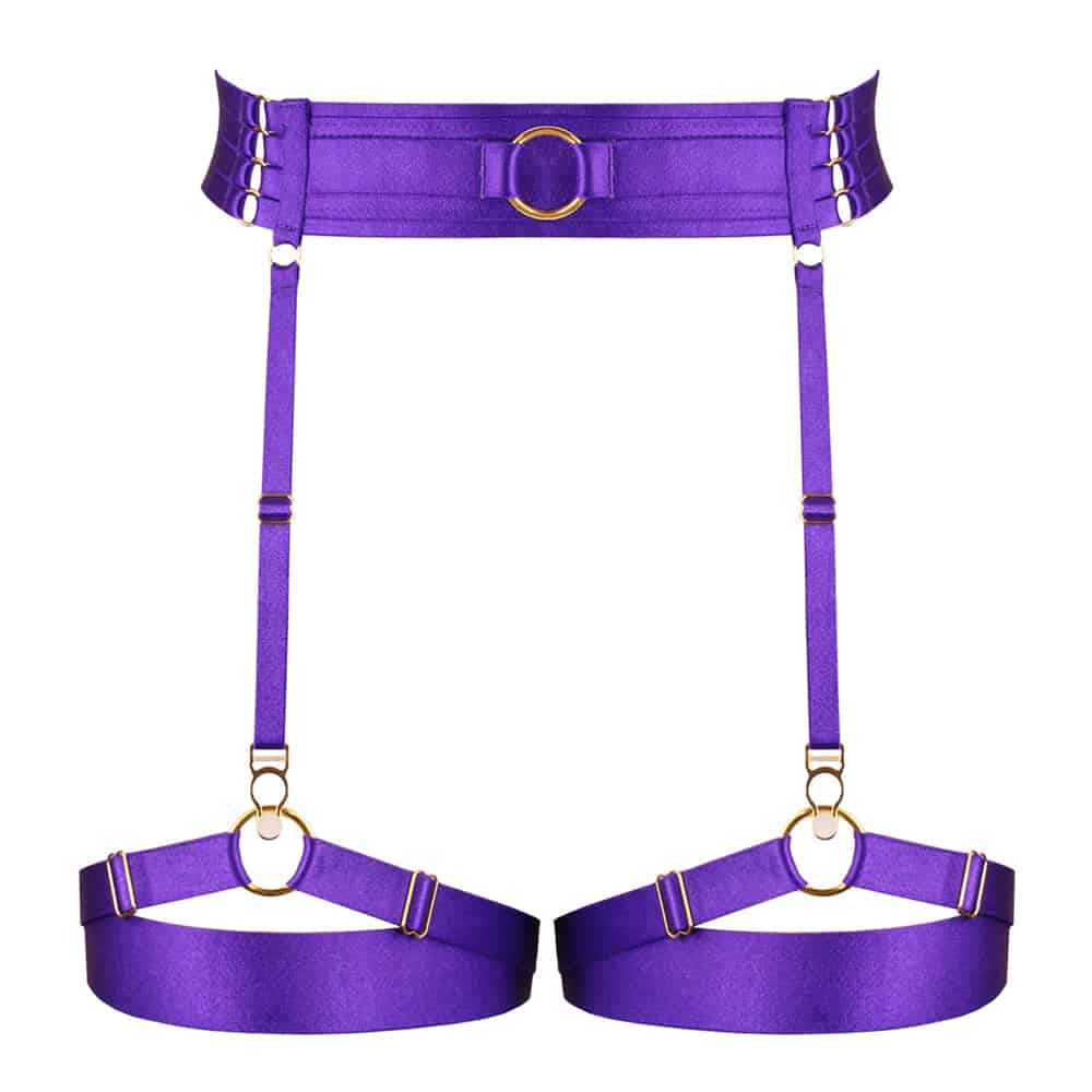 Porte Jarretelles Electra Violet de la marque Kaimin. Ces porte jarretelles ont une forme simple et se singularisent par leur couleur violet excentrique. La ceinture est composé d’un élastique large sur le devant avec un anneau central et sur les hanches se développent quatre petits élastiques qui s’accrochent un à un au dos par de petits crochets dorés. Les Jarretières sont placés en élastiques doubles croisés sur le devant puis qu’âtres petits élastiques.