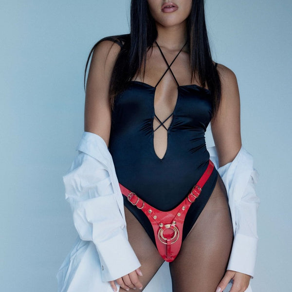 Harnais de pegging STRAP-ON-ME en cuir rouge avec anneau central doré et sangles réglables, sélection Brigade Mondaine Paris.