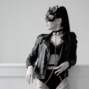 Harnais collier en cuir avec chaîne argentée porté sous blazer noir, body harness femme élégant et audacieux