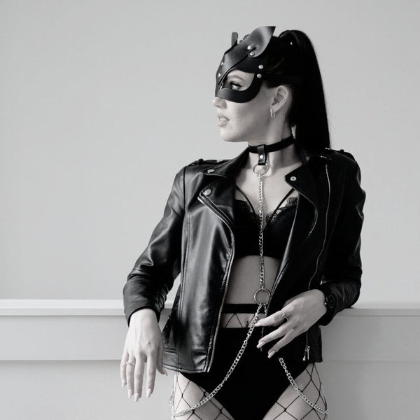 Harnais collier en cuir avec chaîne argentée porté sous blazer noir, body harness femme élégant et audacieux