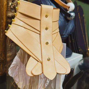 Collier en cuir nude signé Úna Burke, inspiré d'un collier médical pour la colonne vertébrale, avec une finition rock chic et bondage. Création portée dans The Hunger Games – Mockingjay.