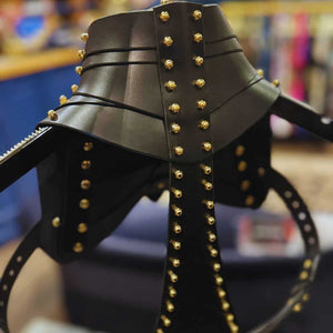 Holster d’épaule en cuir noir signé Úna Burke, inspiré des étuis pour armes à feu, avec raccords en laiton massif recouverts d’or et vis en laiton, créant une pièce rock chic et structurée, portée par des icônes comme Janet Jackson et Rihanna.