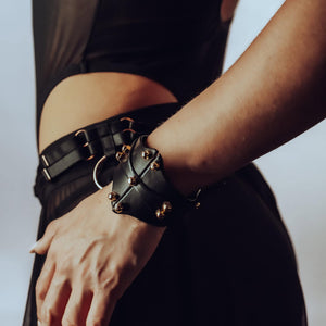 Bracelet de type manchette signée Una Burke en cuir noir de vache tanné végétal les raccords en laiton massif recouverts d’or et les vis en laiton.
