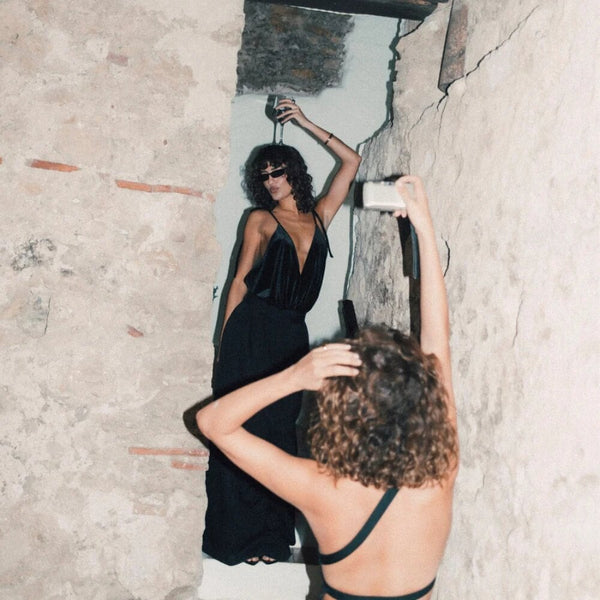 Body noir Undress Code Once in a Blue Moon porté par un modèle, coupe fluide et décolleté plongeant, sélection Brigade Mondaine Paris.