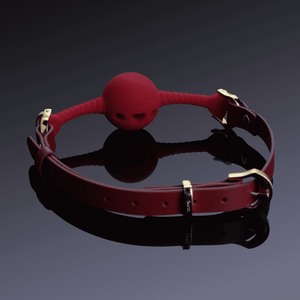 Image sur fond noir du bâillon buccal coeur rouge.