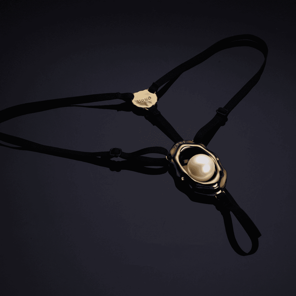 Bijou clitoridien “Moist Eyes” de UPKO avec stimulateur ergonomique et perle roulante. G-String ajustable, détails dorés, alliage de zinc hypoallergénique pour une stimulation et un confort optimaux.