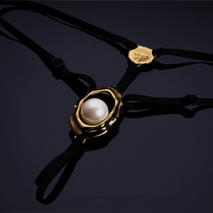 Bijou clitoridien “Moist Eyes” de UPKO avec stimulateur ergonomique et perle roulante. G-String ajustable, détails dorés, alliage de zinc hypoallergénique pour une stimulation et un confort optimaux.