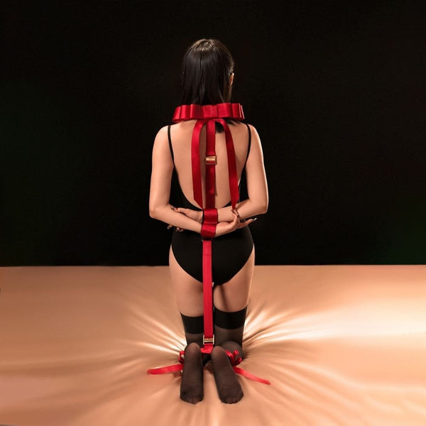 Femme sur les Genoux de Dos portant des Sangles Hogtie Bondage en Rubans Rouges