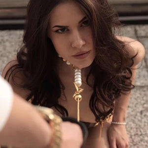 Femme Assise de Devant portant un Collier de Perles et Laisse BDSM Blanc et Or