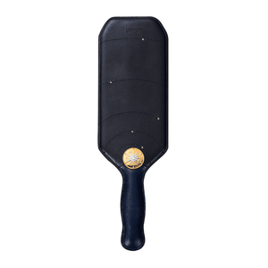 Packshot du paddle de cuir noir avec manche en peau de lézard avec détails en or.