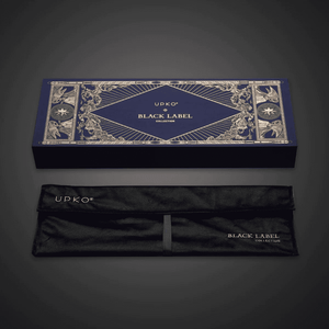 Photographie sur fond noir du packaging bleu et doré, boite avec pochon en velour écris “UPKO BLACK LABEL COLLECTION"