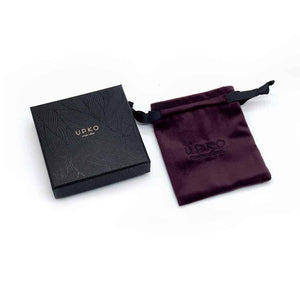 Petite Boite Upko noire avec graffiti avec son petit pochon en velours bordeaux foncé et brodé en fil noir du logo UPKO pour les éditions limitées UPKO X Brigade Mondaine sur fond blanc disponible chez Brigade Mondaine