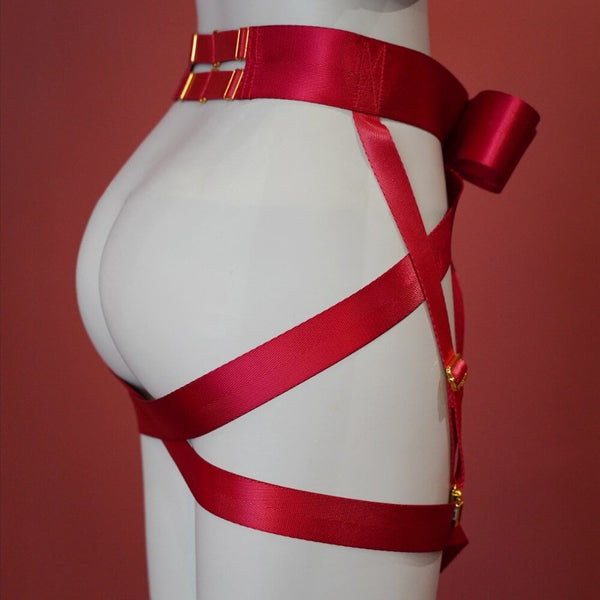 Harnais bas du corps UPKO en sangles croisées noires avec nœud papillon, enlaçant taille et fesses – accessoire bondage élégant et graphique.