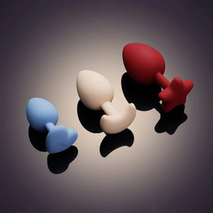 Accessoires anaux UPKO en silicone de différentes tailles 3 cm 3.5 cm et 4 cm présentés sur fond dégradé Brigade Mondaine Paris