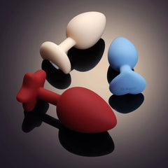 Accessoires anaux UPKO en silicone de différentes tailles 3 cm 3.5 cm et 4 cm présentés sur fond dégradé Brigade Mondaine Paris