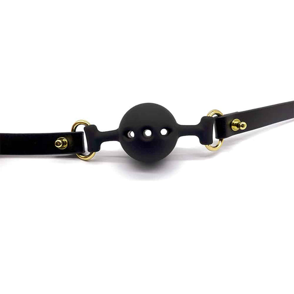 Baillon en cuir noir et silicone en forme de boule avec trous pour respiration, finition or UPKO chez Brigade Mondaine