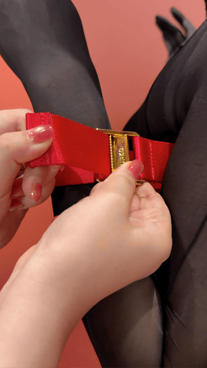Harnais Bowknot UPKO en sangles noires avec nœud papillon central, encadrant poitrine et bras, équipé d’attaches Velcro – harnais haut du corps esthétique et fonctionnel.