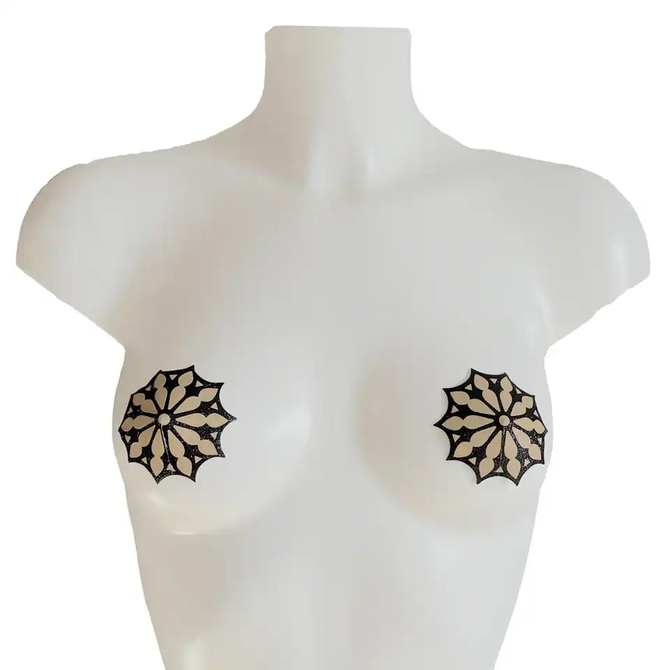 Cache-tétons auto-adhésifs avec motif rosace gothique noir pailleté sur base nude. Matière douce, flexibles et réutilisables. Accessoire de lingerie élégant de la collection DOGMA.