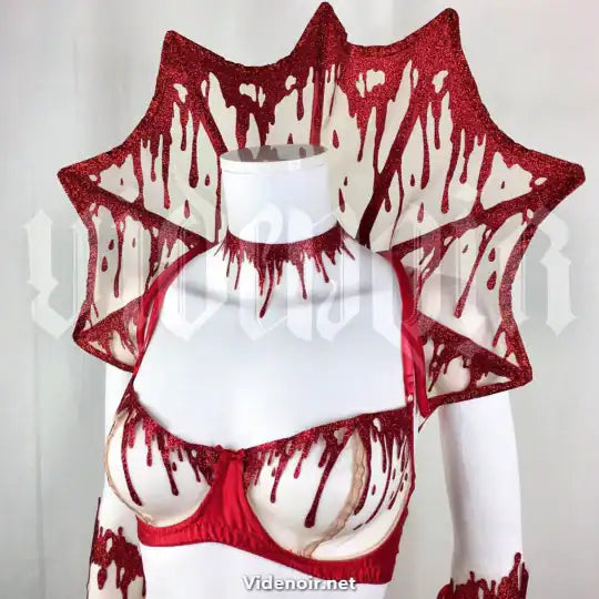 Col Gouttes de Sang VIDE NOIR présenté chez Brigade Mondaine Paris, col rigide rouge pailleté aux motifs de gouttes stylisées, porté sur buste avec finition graphique et sculpturale.