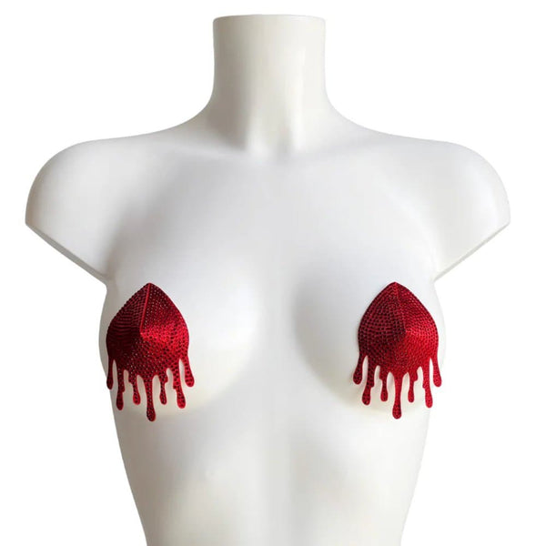 Mannequin portant les cache-tétons Blood rouges VIDE NOIR chez Brigade Mondaine Paris, motifs brodés en forme de gouttes, portés avec un ensemble rouge assorti, photographié en studio.
