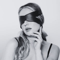 Bandeau X en cuir noir avec sangles ajustables et boucles métalliques, accessoire de bondage proposé par Brigade Mondaine Paris.