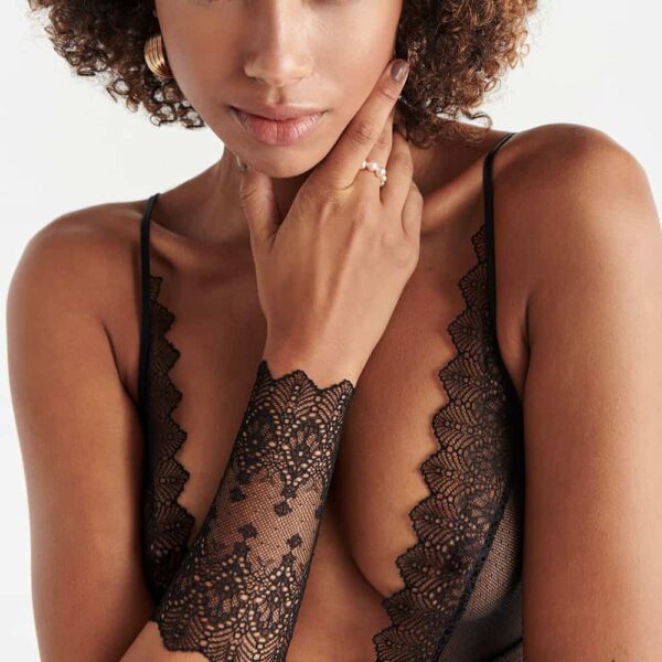 Geneva black lace V-neck bodystocking and Geneva black lace gauntlet in close-up view worn on a white background model from the Geneva collection by Bracli at Brigade Mondaine