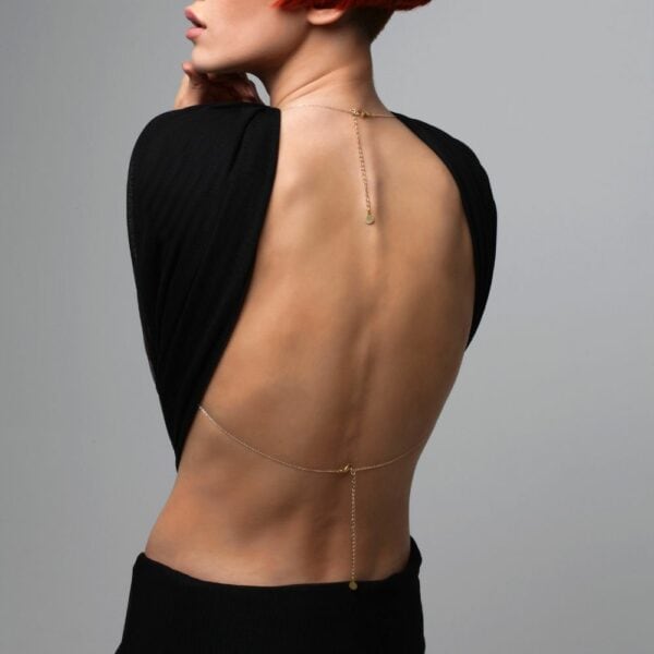 Photo of a Woman from the Back wearing a Gold Body Jewelry with Swarovski Jewelry with a Black Outfit