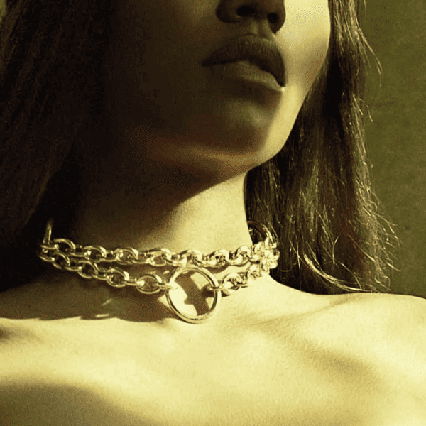 Green photograph of a woman wearing a gold chain necklace