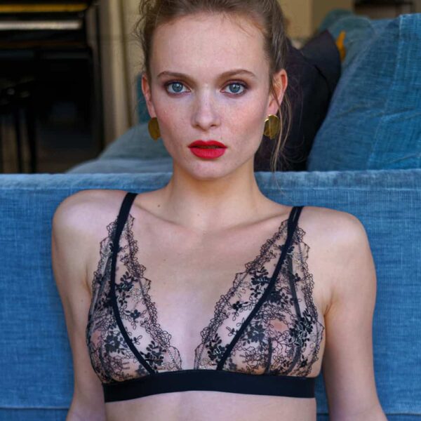 Transparent black lace bra with satin-finish elastic band under the breasts. Product of atelier amour at brigade mondaine.