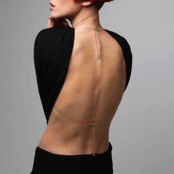 Photo of a Woman from the Back wearing a Gold Bust Jewel with Swarovski Jewelry with a Black Color Outfit