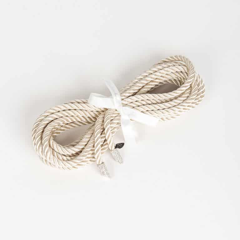 Corde shibari Bianco de chez Fraulein Kink sur Brigade Mondaine.Entièrement réalisée à la main et sur commande à Berlin, dans les ateliers de la marque, à partir de corde de soie; la Corde Shibari Bianco est un accessoire bondage de luxe extraordinaire. Ajoutez un peu d’éclat sexy à votre boudoir avec le lasso de bondage d’une longueur de 5 mètres à pointe de cristal blanc et or. Transformez le lasso comme une ceinture ou un harnais pour ajouter une touche fétiche spéciale à votre tenue préférée.