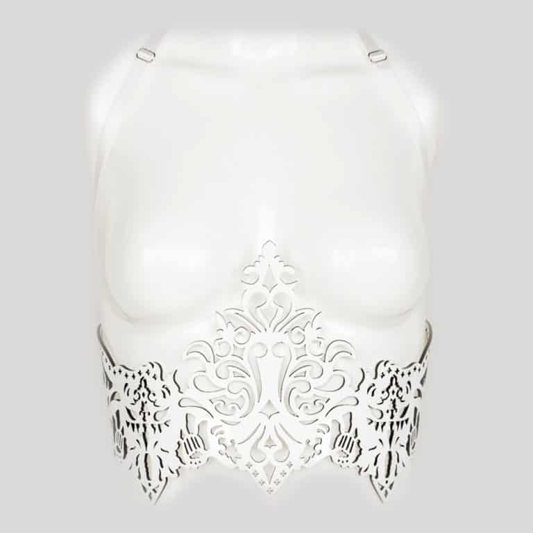 Harnais Underbust de la collection Original Sin Bianco de Fraulein Kink sur Brigade Mondaine. Entièrement réalisé à la main et sur commande, dans les ateliers de la marque à Berlin, à partir de cuir vernis découpé au laser, le Harnais Underbust Bianco ne laissera personne indiffèrent lors de vos soirées fétichistes ou érotiques. Soyez la plus chic avec ce harnais de forme corset en cuir vernis. Il est absolument parfait pour accessoiriser une tenue ou votre lingerie préférée. Les découpes au laser à l’inspiration baroque ajoutent une touche de glamour à l’ensemble. La bretelle est amovible pour transformer la pièce à votre guise. Les élastiques satinés à l’arrière et le crochet permettent d’ajuster ce harnais à votre morphologie. Corsage en cuir verni blanc brillant découpé au laser personnalisé. Rivets à double capuchon cerclés d’argent nacré ivoire. Sangle de licou élastique amovible en satin double face réglable. Fermetures ajustables à crochets au dos.