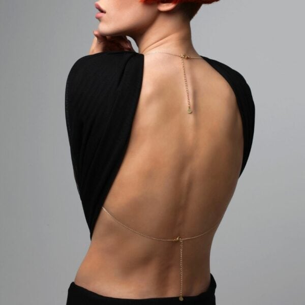 Photo of a Woman from the Back wearing a Gold Body Jewelry with Swarovski Jewelry with a Black Outfit