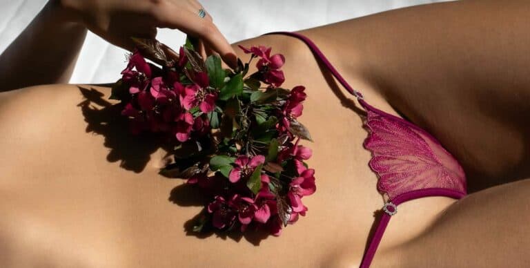 woman with a purple thong and flowers on her belly.