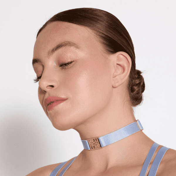 Woman wearing a sky blue choker with thin strap and gold logo details