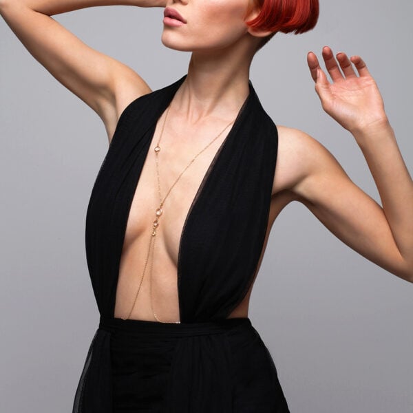 Photo d'une Femme de Devant portant un Bijou de Corps Doré avec une Tenue couleur Noir