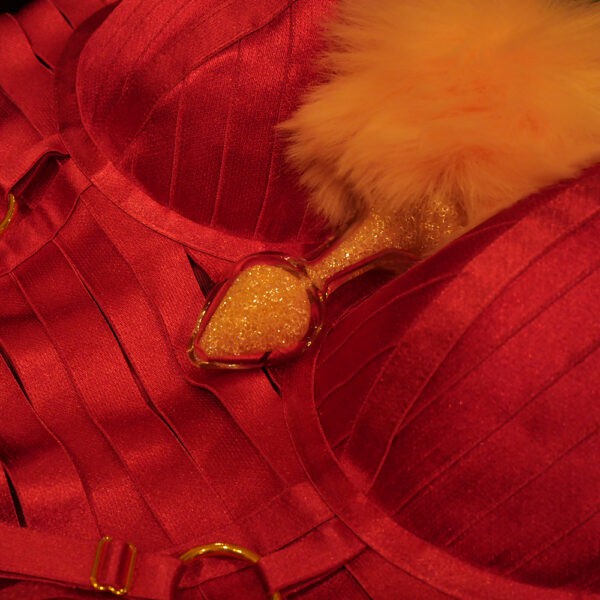Showroom zeigt den Plug Bunny Glitter Rose Crystal Delights auf dem roten Angela Bondage-Kleid Bordelle.