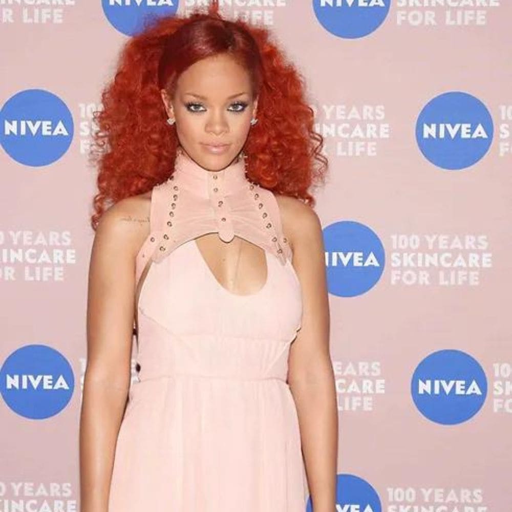 Rihanna portant un haut Una Burke en cuir rose clair sur un tapis rouge.