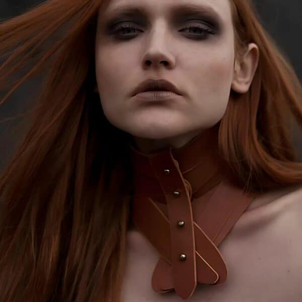 Close-up woman wearing a brown leather UNA BURKE necklace.