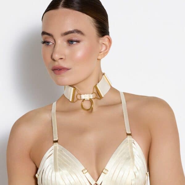 Detail of a Photo of a Front Woman Wearing a Crop Top and Necklace with Cream Color Ring